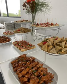 a buffet table filled with different types of food on plates and trays full of appetizers