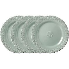 four white plates sitting on top of each other in front of a white background with an ornate design