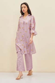 Lilac shirt tunic with floral embroidery, tie-up detail and frill sleeves. Comes with pant.
Component: 2
Pattern: Embroidered
Type Of Work: Floral
Neckline: Spread Collar
Sleeve Type: Frill Sleeves
Fabric: Silk, Cotton Chanderi
Color: Purple
Other Details: 
Floral embroidery
Closure: Front buttons
Occasion: Work - Aza Fashions Summer Embroidered Sleeves Straight Kurta Set, Summer Sets With Embroidered Sleeves And Straight Kurta, Summer Straight Kurta Set With Embroidered Sleeves, Summer Straight Kurta With Embroidered Sleeves, Summer Resham Embroidery Long Sleeve Pant Set, Spring Cotton Tunic Set, Spring Cotton Sets With Embroidered Sleeves, Casual Floral Embroidered Sets For Eid, Casual Eid Sets With Floral Embroidery