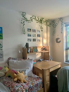 a bedroom with a bed, desk and window in the corner that has ivy growing on it