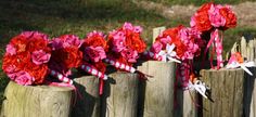 pink and red flowers are placed on wooden posts