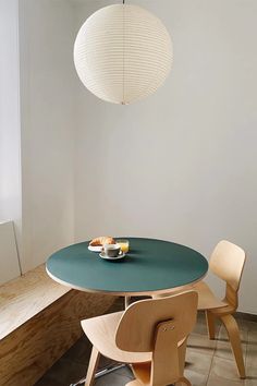 a blue table with two chairs and a bowl of fruit on it