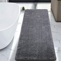 a bathroom rug is on the floor next to a bathtub