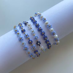 the bracelets are decorated with blue and white glass beads, gold - plated accents