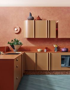 a kitchen with orange walls and wooden cabinets