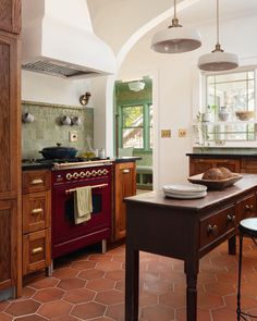 a kitchen with an oven, stove and table in it's center island surrounded by wooden cabinets