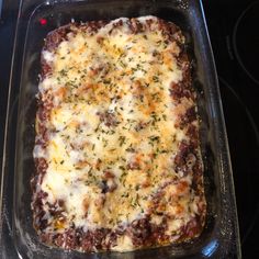 a casserole dish with cheese and meat in it on a stove top oven