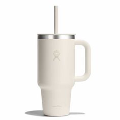 a white coffee cup with a straw sticking out of it