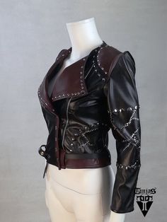 Unique one of a witchy biker jacket, produced with precision and patience, out of a scratch.  Jacket is made of black and dark red wine eco leather which has exquisite soft quality. Slightly pointy shoulder sleeves are solid and firm, sleeves are made of semi-elastic leatherette which secures fine tight fitting. One of a kind design, made from scratch, artistic clothing - no other like this will be made again. Size fits best to EU 36/38 (in shoulders), but jacket design size is adaptable. Dimensions: Bust - 86 to 96 cm Waist - 72 to 78 cm Sleeve l. - 54 cm Biceps - 26 to 27 cm Shoulders - 37 cm .: secured shipping with the tracking number included