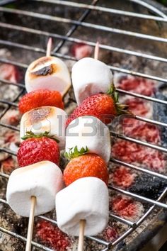 strawberries and marshmallows are being grilled on the grill