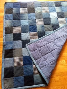 a quilted blanket laying on top of a wooden floor