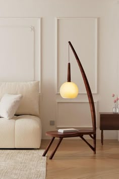 a living room with a white couch and wooden floor lamp in it's corner