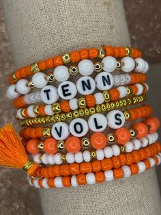 The ultimate bracelet listing for any University of Tennessee fan! Go Vols! These bracelets are SOLD INDIVIDUALLY & as a STACK of 10! If wanting multiple bracelets, please add each one individually to your cart! Bracelets with letter beads can be personalized to exchange for a different word/name or player number. PERSONALIZATION IS *ONLY* FOR BRACELETS THAT COME WITH LETTER BEADS! (This is important as we have different price points for our goods!) Please use the personalization box if wanting this; otherwise, your bracelet will come as pictured! Personalization Box: PERSONALIZATION ONLY APPLIES TO BRACELETS PICTURED WITH LETTERED BEADS! Please add name/word/player number exactly as you want it on your bracelet. We use Czech glass beads and 18k gold plated beads to create these spirited b Tennessee Bracelets, Team Bracelets, Items For College, Football Bracelet, Go Vols, Tennessee Vols, Bracelet Stacks, Multiple Bracelets, Handmade Jewlery