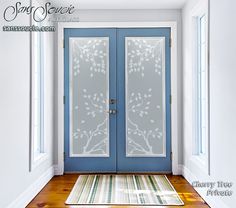 a blue front door with two glass panels and a rug on the floor next to it