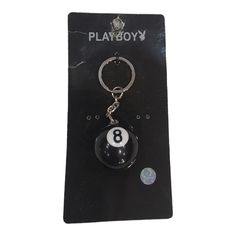 a keychain with a black ball and number 8 on it in front of a white background