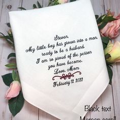 a white handkerchief with a poem written on it and flowers in the corner next to it