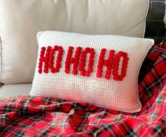 a crocheted pillow with the word ohoh on it sitting on a bed