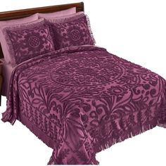 a bed with purple bedspread and pillows