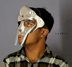 Welcome To HEBEAK World  MF Doom-Inspired Premium Face Mask: Wear Your Favorite Villain Authentic MF Doom Mask Halloween & Christmas Gift Silver Plating Finish Metal : Aluminium & Leather  Size : Adult Size Fully Adjustable  Step into the world of hip-hop legend MF Doom with our stunning Silver Mask, inspired by the iconic villain himself. Crafted from high-quality materials, this mask combines style and comfort, making it perfect for fans, collectors, or anyone looking to make a bold statement. Features: Craftsmanship & Design: Meticulously crafted, the MF Doom Silver Mask features an eye-catching silver Plating finish that reflects light beautifully, making it stand out in any setting. The intricate detailing showcases the artistry synonymous with MF Doom's music and persona, from the sh Mf Doom Mask, Silver Mask, Mf Doom, Hip Hop Culture, Halloween Christmas, Costume Party, Costume Accessories, Face Shapes, Aura