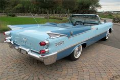 an old blue car is parked on the street