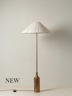 a lamp that is on top of a table next to a white wall with the word new written below it