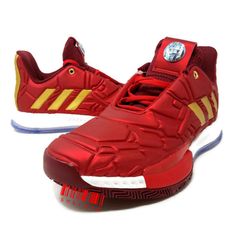 the adidas basketball shoe is red with gold details on the upper and bottom part