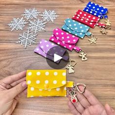 a person is holding a small wallet in front of some christmas decorations and snowflakes