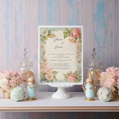 a table topped with vases filled with flowers next to an ornate card and candle holder