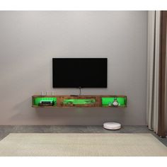 a flat screen tv mounted to the side of a wall next to a remote control