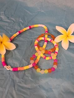 three bracelets with flowers and beads on a blue sheet