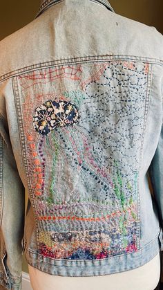 a denim jacket with jellyfish embroidered on the back