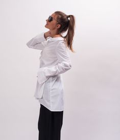 Easy and breezy, the Unstoppable Cotton womens white shirt features an asymmetrical construction, a wide avant garde collar, relaxed sleeves, and an asymmetrical button closure. With black pants, this white cotton long sleeve shirt makes Monday mornings bearable. The White asymmetrical shirt is designed to be comfortable and not troublesome to wear. After wearing this White long sleeve shirt women, you will love it even more. The white blouse for women is made of high quality fabric with cottone Oversized Long Sleeve Minimalist Tops, Asymmetrical Summer Blouse With Buttons, Oversized Asymmetrical Cotton Blouse, Versatile White Blouse With Shirttail Hem, White Asymmetrical Cotton Shirt, Asymmetrical Summer Workwear Shirt, Oversized Summer Office Tops, White Asymmetrical Tops For Workwear, White Asymmetrical Tops For Work