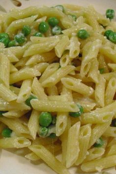 a white plate topped with pasta and peas