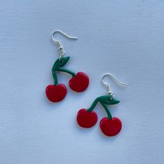 These polymer clay earrings feature red cherries! **Please note that these earrings are handmade and each pair may differ slightly Trendy Red Resin Earrings, Handmade Red Polymer Clay Earrings, Red Drop Earrings In Polymer Clay, Playful Nickel-free Red Earrings, Playful Handmade Red Earrings, Cute Red Resin Jewelry, Handmade Cherry Cute Earrings, Cute Handmade Red Earrings, Handmade Cute Cherry Earrings