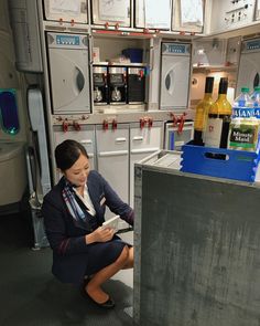 a woman sitting on the floor in an airplane kitchen