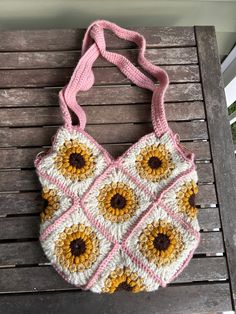 a crocheted purse sitting on top of a wooden bench