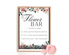 a flower bar sign with pink flowers and greenery