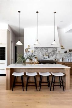 a kitchen with marble counter tops and stools