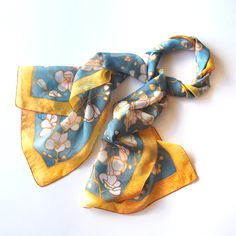 Gold sakura scarf was hand painted on delicate Habotai silk with a detailed pattern of blooming cherries on blue background. This silk scarf is ready to be shipped! Size: 61 by 17 inches (155 by 43 centimeters) Silk: pure silk Habotai Light, semi transparent and a bit glossy This blue silk scarf was hand painted directly on the fabric so the pattern is equally visible on both sides. The detailed pattern is stylized on Art Nouveau designs. You can see gold framed cherry blossom flowers with dark Blue Vintage Silk Scarf For Gift, Vintage Blue Silk Scarf As Gift, Vintage Blue Silk Scarf For Gift, Vintage Blue Floral Print Scarves, Blue Vintage Silk Scarf For Spring, Vintage Blue Silk Scarf For Spring, Blue Floral Print Silk Scarf For Gift, Blue Floral Print Silk Scarf As Gift, Painted Silk Scarves