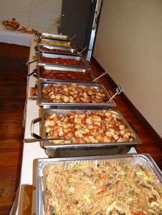 many trays of food are lined up on the table