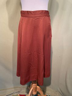 This is a lovely vintage skirt, from the 1950s or early 60s. No brand labels. Appears home sewn. Waist measures 30", please see measurements.  Made of a brown cotton blend. It is an A line skirt. Closes on the waistband with a pair of buttons & a metal zipper.  It has a 2-3/4" hem.  The skirt is in good condition. No soil or stains.  No holes or tears. No fading.    Lovely! Measurements were taken with the garment lying flat. If you have never worn vintage before, please measure yourself!! Will fit best if your measurements are a little smaller than the measurements given. If you have any questions about measuring, please ask before purchasing. Waist measured from side seam to side seam: 13.5" for a 27" waist Hip from side seam to side seam 20" for a 40" or smaller hip Length: 26" Vintage Brown Flowy Skirt, Vintage Knee-length Brown Skirt, Vintage Brown Knee-length Skirt, Vintage Solid Color Lined Skirt, Vintage Brown Skirt For Workwear, Vintage Brown Skirt For Work, Vintage Long Brown Skirt, Brown Vintage Skirt, Vintage Brown Skirt