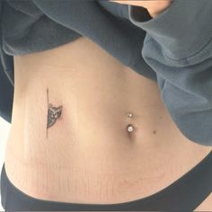 a woman's stomach with a small tattoo on the side and an arrow in the middle