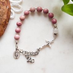 I designed it specifically to have a subtle dusty pink look to satiate a love pink without being *too* girly. The perfect look for honoring Mary as the Rosa mystica, the Mystical Rose. Stylish, practical, and comfortable, this rosary bracelet has been my go-to rosary for months. BRACELET SIZING Lobster clasp and chain make the new bracelets far more adjustable than the old designs. Two sizes are available: Small and Medium/Large. The only difference is the length of the chain. Small goes from 7″ Handmade Rose Quartz Jewelry For Everyday, Adjustable Rosary Bracelet For Everyday Wear, Adjustable Pink Crystal Bracelet With Gemstone Beads, Adjustable Pink Crystal Bracelet With Natural Stones, Pink Crystal Bracelet For Everyday Wear, Adjustable Pink Rosary Bracelet With 8mm Beads, Pink Round Rosary Bracelet Gift, Adjustable Handmade Pink Rosary Bracelet, Pink Rose Quartz Beaded Bracelets