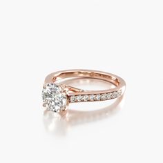 a rose gold engagement ring with an oval cut diamond in the center and side stones on each band