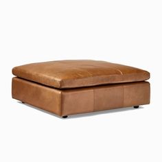 a brown leather ottoman sitting on top of a white floor