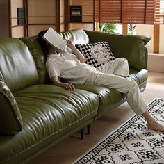 a woman sitting on top of a green couch