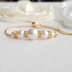 Pearl Bracelet in 14K Gold Finish for Weddings, Brides & Bridesmaids The Ava 14K gold pearl bracelet is a classic and is available in ivory/white pearls and cream pearls. The gold and pearl wedding pearl bracelet is wire wrapped in a combination of soft crystal pearls and sparkly rhinestones beads. This simple yellow gold and pearl bracelet are put onto an adjustable chain with slider clasps, lovely as a pearl bracelet for bridesmaid, for flower girls gifts & as a bridal bracelet.These beautiful Wedding Pearl Bracelet, Gold And Pearl Bracelet, Pearl Bracelet Wedding, Gold Pearl Bracelet, Flower Girl Gifts, Pearl Cream, Ivory Pearl, Bridal Bracelet, Bridesmaid Flowers