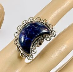 "A blue moon to wear upon your finger! This is a large crescent moon ring. I had the stone specially cut for this design. The blue lapis lazuli is nice size and thickness This is set into a sterling bezel that is framed with a silver wire accent. Sterling scalloped loops frame the piece for more detail. The blue lapis is a gorgeous color of cobalt blue with tiny touches of pyrite. The ring band has a split shank.  It makes a statement on your finger! This is one of several crescent moon pieces t Blue Bohemian Moonstone Ring, Blue Celestial Moonstone Ring, Handmade Celestial Blue Rings, Handmade Blue Celestial Rings, Crescent Moon Ring, Lapis Ring, Blue Lapis Lazuli, Lapis Lazuli Ring, Moon Ring