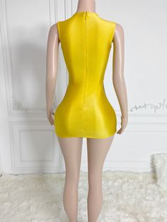 a mannequin wearing a yellow bodysuit in front of a white wall and floor