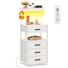 a white shelf with drawers next to a remote control and an orange light on the wall